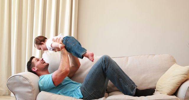 Father Playing with Baby on Sofa at Home - Download Free Stock Images Pikwizard.com