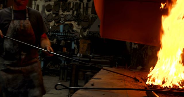 Midsection of caucasian male blacksmith lighting fire in forge in workshop - Download Free Stock Photos Pikwizard.com