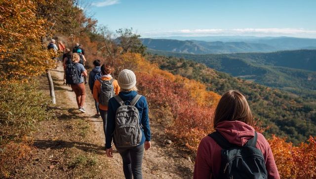 Group Hiking Along Autumn Ridge Overlooking Expansive Valley and Forested Vista
