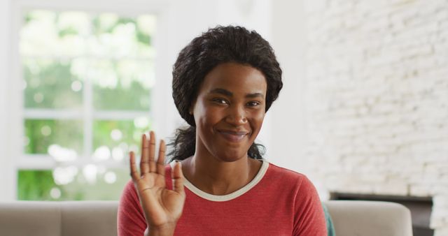 Smiling African American Woman Waving at Camera in Living Room - Download Free Stock Images Pikwizard.com