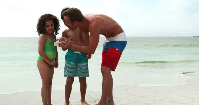 Father Showing Children Photos on Smartphone at Beach - Download Free Stock Images Pikwizard.com