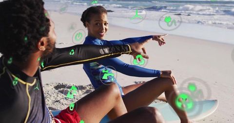 Surfers pointing at waves with digital technology integration