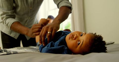 Father Assisting Child with Change of Clothes at Home