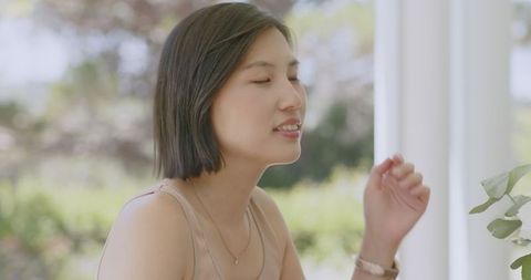 Woman enjoying moment with serene expression indoors