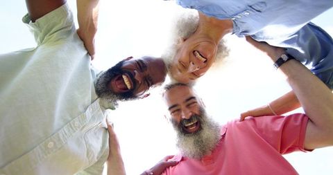 Senior Friends Laughing and Embracing Outdoors During Leisure Time