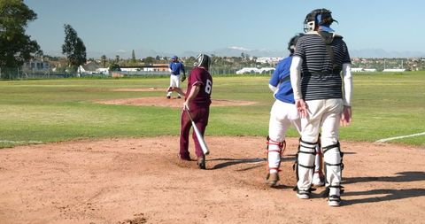 Male Baseball Players Competing Under Clear Sky on Ballfield