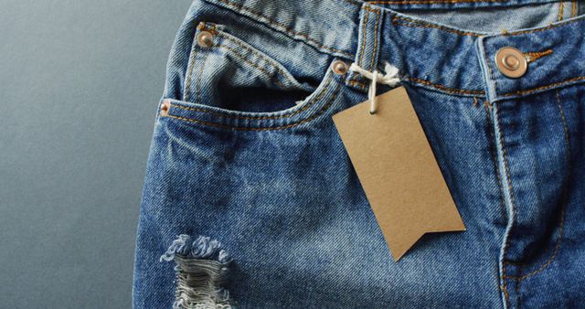 Close up of jeans with tag on grey background with copy space. Denim day, material, style and design concept.