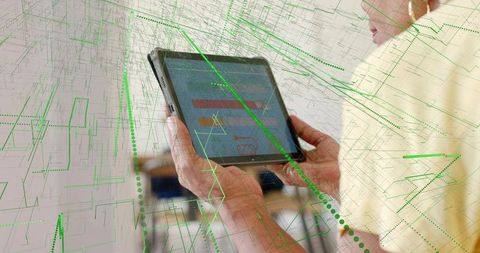 Senior woman holding tablet tapping screen with green data overlay and ar gridlines