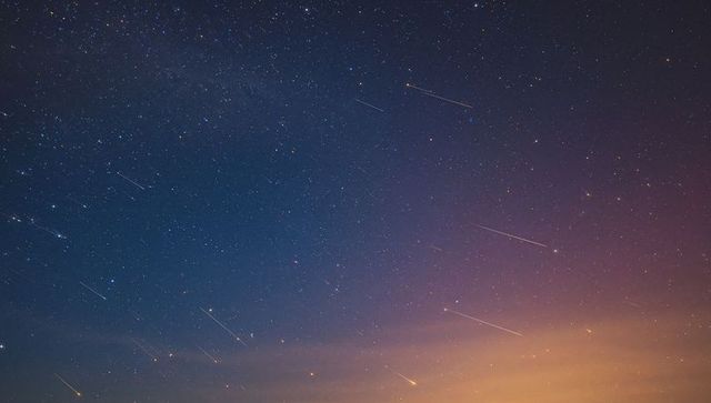 Starry Night Sky with Meteor Shower and Vibrant Dusk Colors