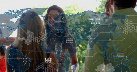 Team collaborating with digital world map overlay and hexagonal interface on glass