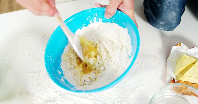 Close-Up of Hands Mixing Ingredients in Blue Bowl for Baking - Download Free Stock Images Pikwizard.com