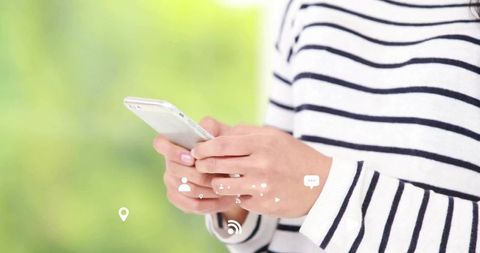 Woman Wearing Striped Sweater Using Smartphone Outdoors
