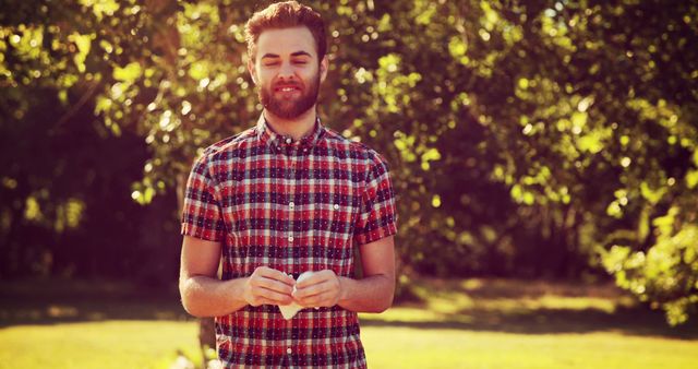 Man Smiling Outdoors on Sunny Day with Trees in Background - Download Free Stock Images Pikwizard.com