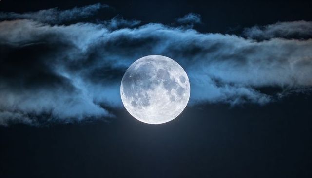 Full Moon Illuminating Thin Cloud Veil Over Night Sky, Detailed Lunar Craters and Halo