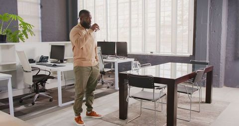 Thoughtful Businessman Drinking Coffee in Modern Office