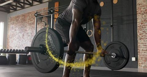 Athlete performing heavy deadlift with chalk dust trail in industrial gym for strength training