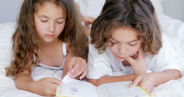 Siblings Reading Book Together on Bed in Cozy Room - Download Free Stock Images Pikwizard.com