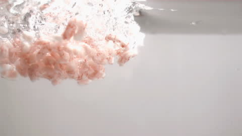 Peeled Shrimps Falling into Water in Slow Motion