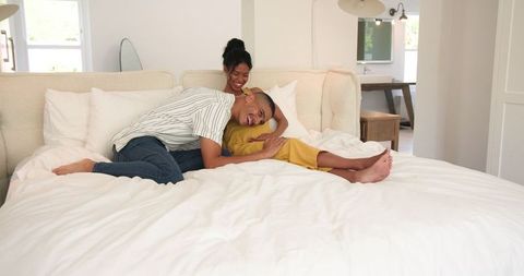 Couple Relaxing on Bed Embracing Bonding and Joyful Laughter