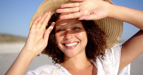 Carefree Woman Enjoying Sunny Beach Day with Radiant Smile