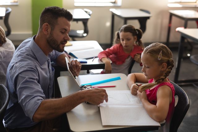 Teacher assisting young student with schoolwork in classroom. Ideal for educational content, school brochures, teaching materials, and articles on child development and education.