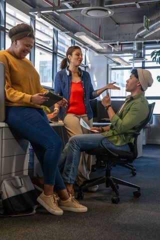 Diverse team collaborating in modern open-plan office discussing project