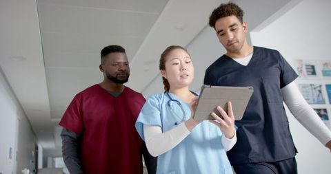 Diverse Healthcare Team Analyzing Data in Hospital Corridor