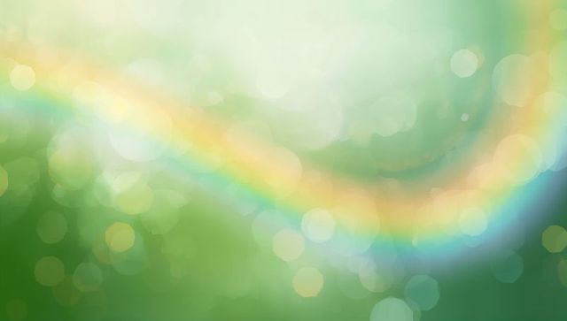 Shimmering rainbow arc flowing across soft green bokeh background with warm luminous glow