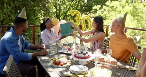Joyful birthday celebration in sunlit garden with friends