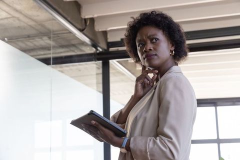 Professional Woman Contemplating with Tablet in Modern Office