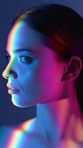 Vertical neon portrait showing model rotating head through chromatic light reveal