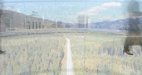 Forest highway reflecting urban skyline with walking boots silhouette double exposure