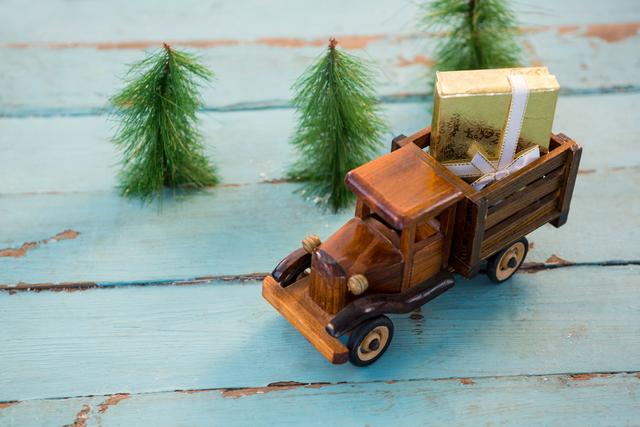Toy tempo carrying christmas present on wooden plank during christmas time