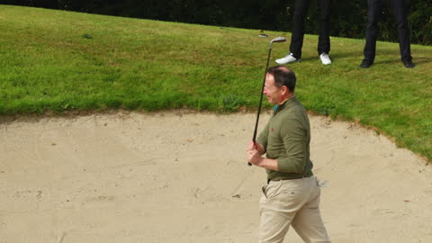 Man Relaxed on Golf Course Walking Near Sand Trap