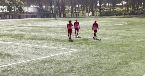 Youth soccer players practicing dribbling and teamwork on sunny field