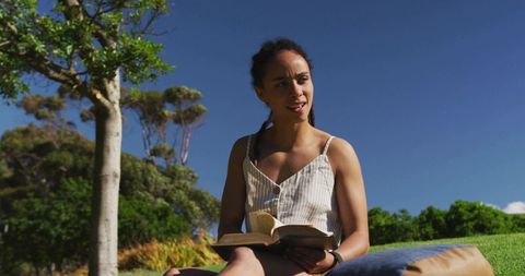 Young Woman Enjoying a Book in Sunny Park