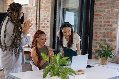 Diverse Team Applauding and Smiling in Modern Office Environment