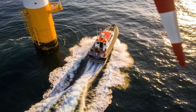 Offshore rescue crew navigating high-speed pilot boat cutting wake near navigation tower