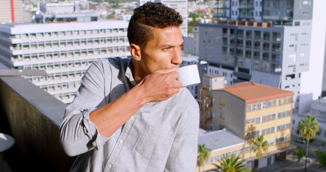 Young Man Drinking Coffee on City Balcony - Download Free Stock Images Pikwizard.com