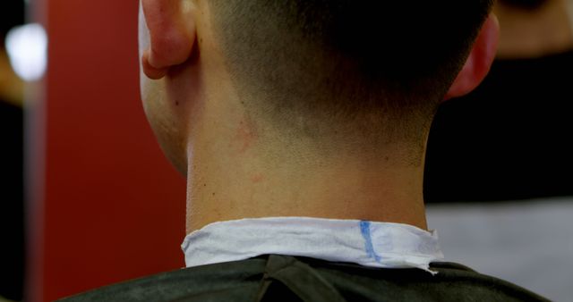 Close-up of a young Caucasian man's neck showing a fresh haircut, with copy space. It captures a moment of grooming, highlighting the neatness and precision of the barber's work.