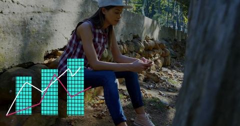 Young woman using smartphone outdoors with analytics overlay for personal finance app