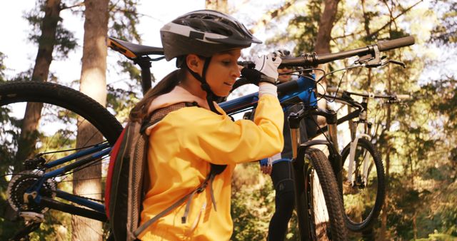 Girl Carrying Mountain Bike in Forest Wearing Helmet and Jacket - Download Free Stock Photos Pikwizard.com
