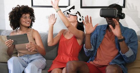 Friends Using VR Headsets and Tablet in Modern Living Room