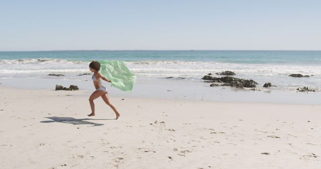 Child Running on Beach with Green Scarf on Sunny Day - Download Free Stock Images Pikwizard.com