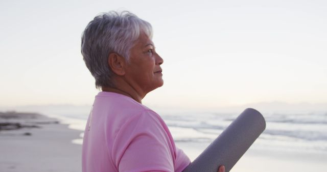 Senior Woman Holding Yoga Mat on Beach at Sunrise - Download Free Stock Images Pikwizard.com