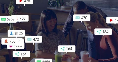 Diverse team collaborating over tablet in cafe with floating social media notifications overlay