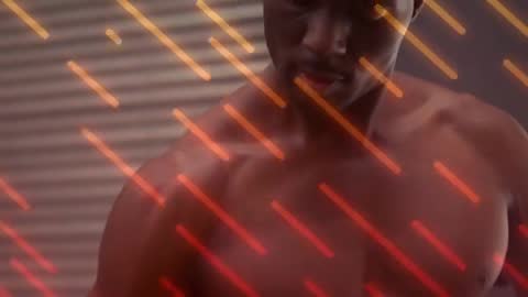 Black man performing slow biceps curl with hex dumbbell amid orange light streaks