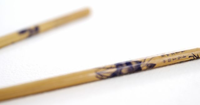 Traditional bamboo chopsticks with intricate Japanese calligraphy. Ideal for use in articles, blogs, and videos about Asian cuisine, Japanese culture, and traditional dining tools. Perfect for background images, cultural presentations, or educational material about Japanese customs.