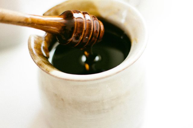 Close-up of Dark Honey in Ceramic Jar with Honey Dipper - Download Free Stock Photos Pikwizard.com