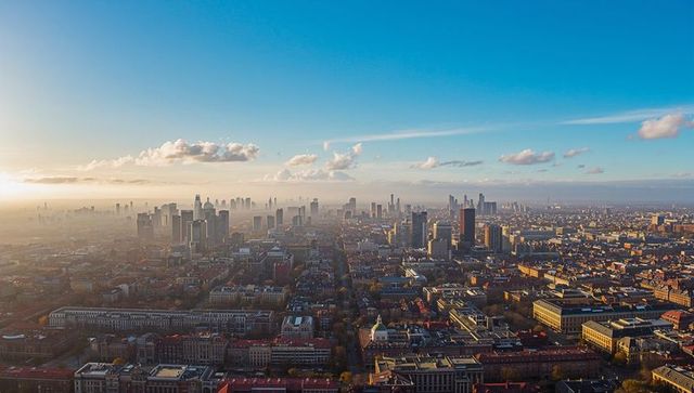 Golden Sunset Glowing Over Urban Skyline Aerial Panorama Featuring Skyscrapers and Rooftops